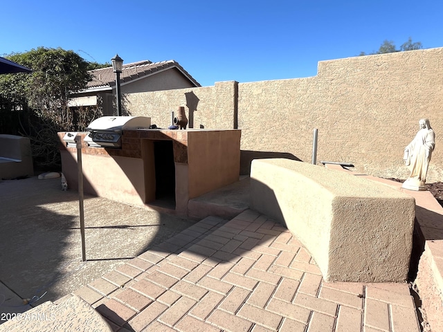 view of patio / terrace featuring exterior kitchen, area for grilling, and fence