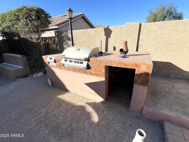 view of patio / terrace featuring grilling area, an outdoor kitchen, and fence