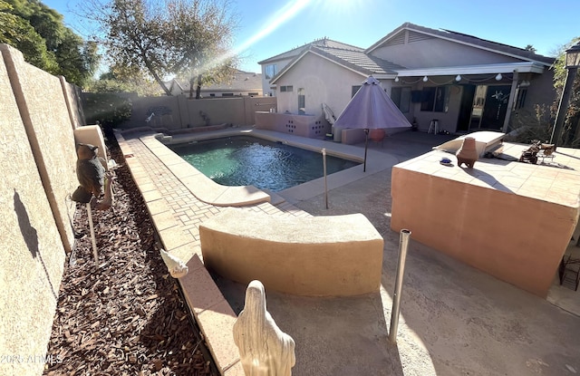 view of swimming pool featuring a fenced in pool, a fenced backyard, and a patio area