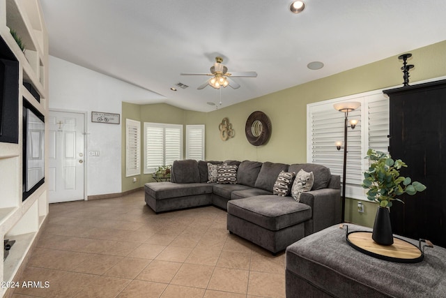 living area with lofted ceiling, light tile patterned flooring, visible vents, a ceiling fan, and baseboards