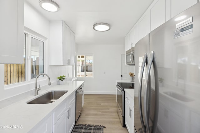 kitchen featuring white cabinets, appliances with stainless steel finishes, and a sink