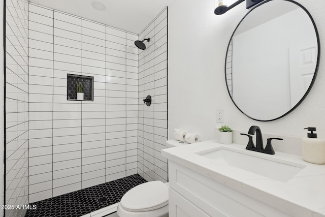 bathroom featuring vanity, a shower stall, and toilet