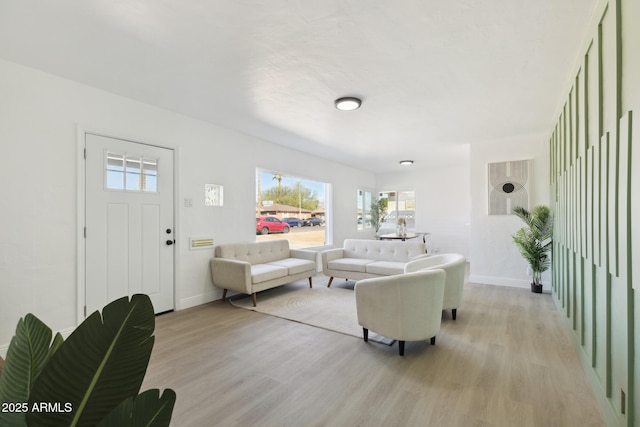 living area featuring light wood-style flooring and baseboards