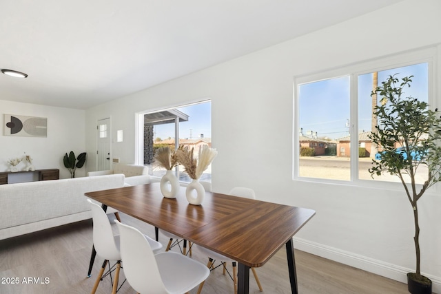 dining space with wood finished floors and baseboards