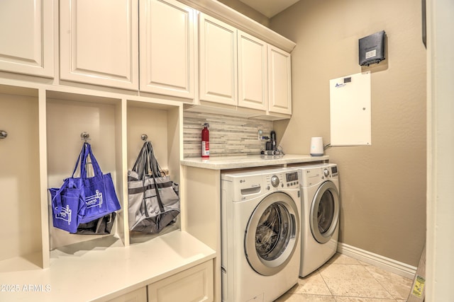 washroom featuring cabinets, washer and dryer, and light tile patterned floors