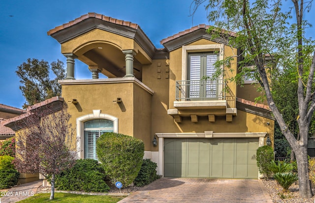 mediterranean / spanish-style house featuring a garage and a balcony