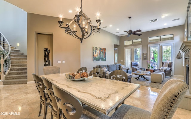 tiled dining area featuring ceiling fan with notable chandelier