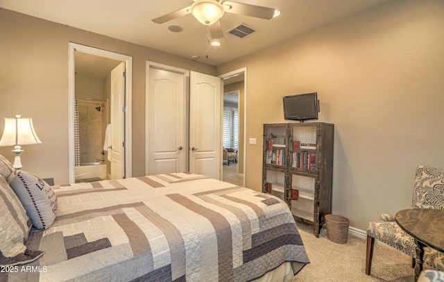 bedroom featuring light carpet, ceiling fan, and ensuite bath