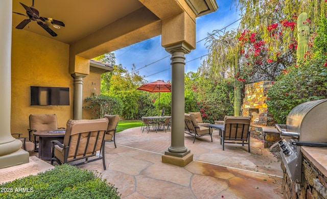 view of patio with ceiling fan and an outdoor living space with a fire pit