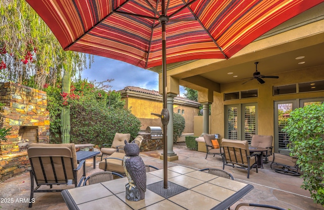 view of patio / terrace with ceiling fan, an outdoor living space with a fireplace, and area for grilling