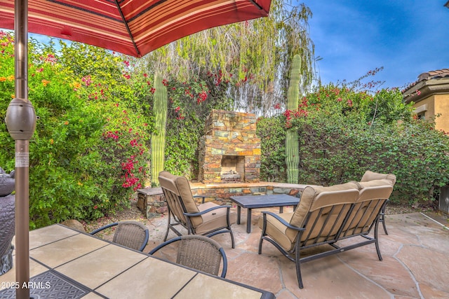 view of patio / terrace with an outdoor living space with a fireplace