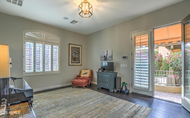 sitting room with dark wood-type flooring and plenty of natural light