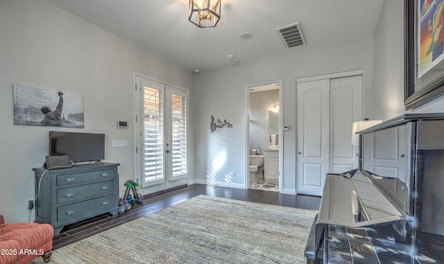 bedroom with ensuite bath, dark wood-type flooring, access to exterior, french doors, and a closet