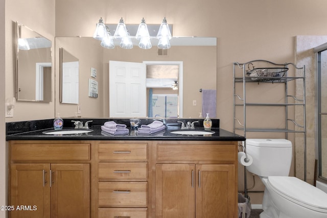 full bathroom featuring toilet, a shower with shower door, and double vanity