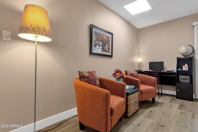 sitting room featuring light wood finished floors, an office area, and baseboards
