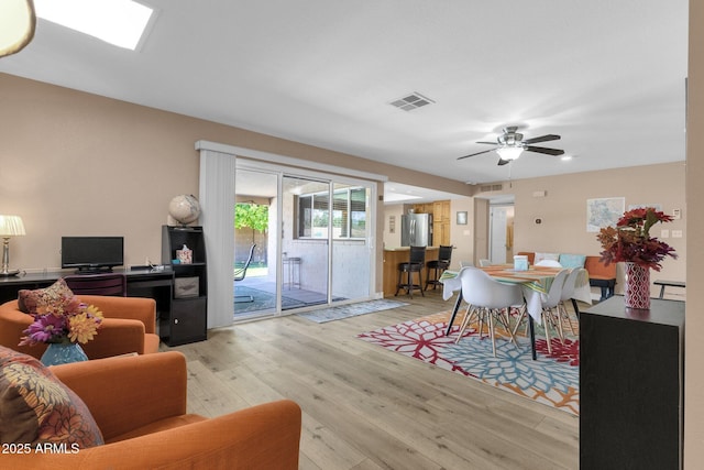living room featuring light wood-style flooring and ceiling fan