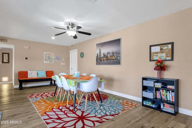 dining room with baseboards, wood finished floors, ceiling fan, and recessed lighting