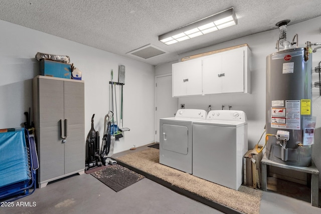 washroom with water heater, independent washer and dryer, cabinet space, and a textured ceiling