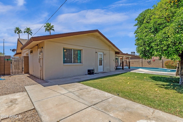 back of property with a gate, a patio, and brick siding