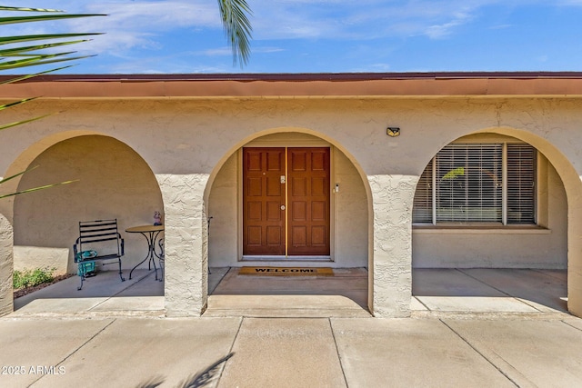 doorway to property featuring stucco siding
