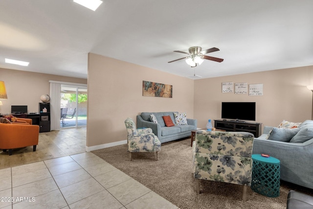 living room featuring a ceiling fan, tile patterned flooring, and baseboards