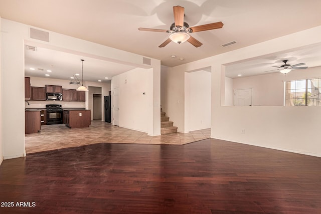 unfurnished living room with sink, light hardwood / wood-style flooring, and ceiling fan