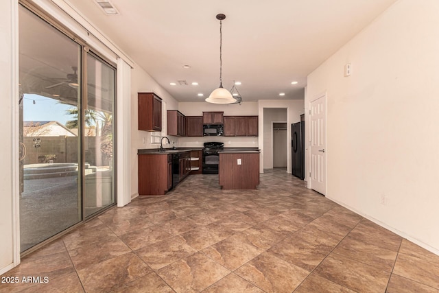 kitchen featuring decorative light fixtures, sink, a center island, black appliances, and dark brown cabinets