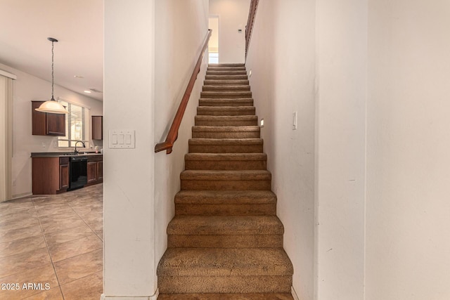 stairs featuring tile patterned flooring and sink