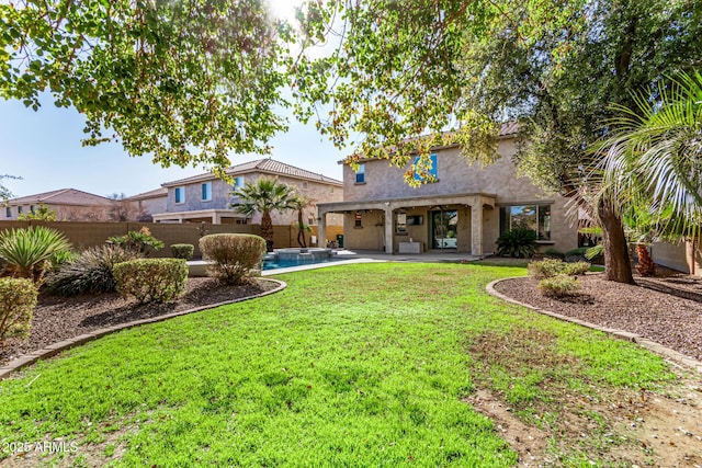 back of property featuring a fenced in pool, a yard, and a patio area