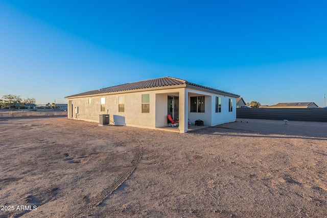 rear view of house featuring central AC unit and a patio area