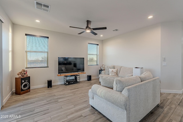 living room with ceiling fan and light hardwood / wood-style flooring