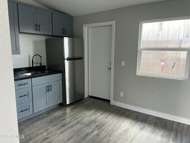 1917 E Monroe St, Phoenix, AZ 85034 - kitchen featuring a sink, freestanding refrigerator, dark countertops, light wood-style floors, and baseboards