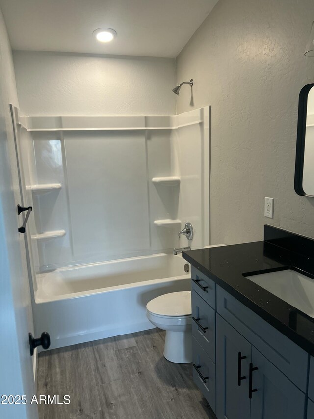 1917 E Monroe St, Phoenix, AZ 85034 - full bath featuring wood finished floors, toilet, a textured wall, bathing tub / shower combination, and vanity