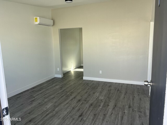 1917 E Monroe St, Phoenix, AZ 85034 - empty room featuring baseboards, a wall mounted AC, and dark wood finished floors