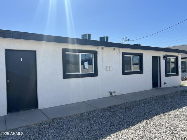 1917 E Monroe St, Phoenix, AZ 85034 - view of side of home featuring stucco siding and central air condition unit