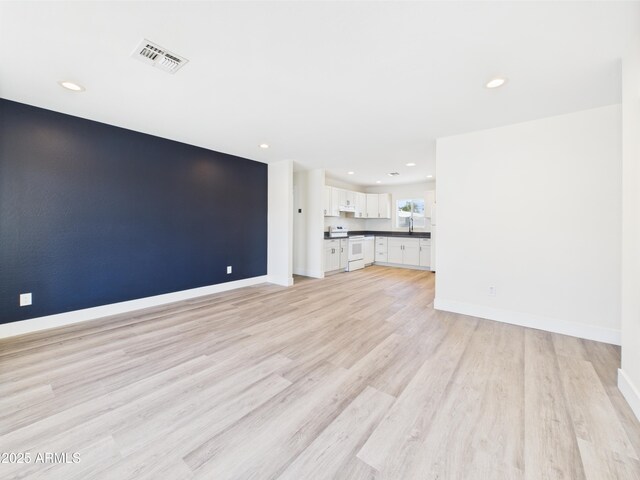 1917 E Monroe St, Phoenix, AZ 85034 - unfurnished living room featuring light wood-style flooring, baseboards, and recessed lighting