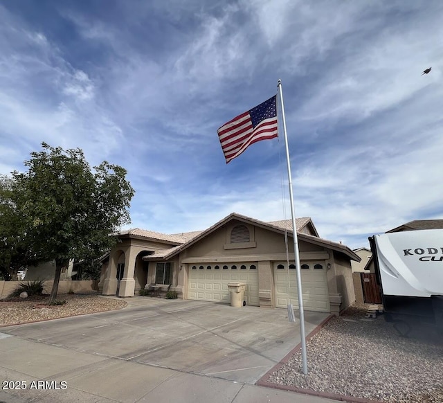 8981 W Tuckey Ln, Glendale, AZ 85305 - view of front of home with stucco siding, an attached garage, and driveway