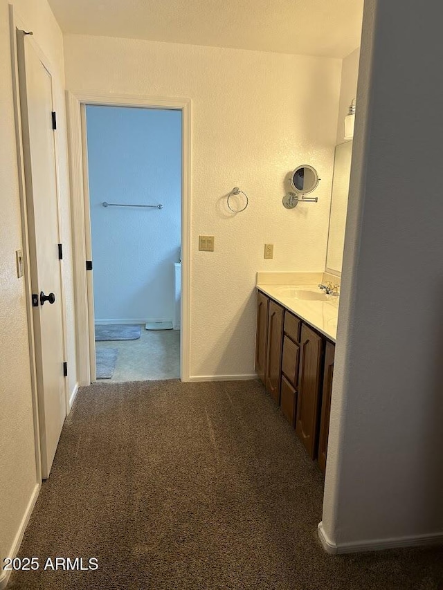 8981 W Tuckey Ln, Glendale, AZ 85305 - bathroom with vanity, a textured wall, baseboards, and carpet flooring