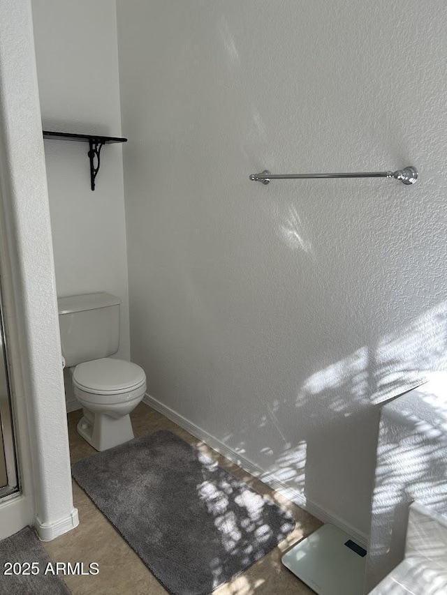 8981 W Tuckey Ln, Glendale, AZ 85305 - bathroom with toilet, baseboards, and a shower with shower door