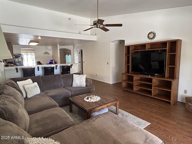 8981 W Tuckey Ln, Glendale, AZ 85305 - living area featuring arched walkways, wood finished floors, ceiling fan, and baseboards