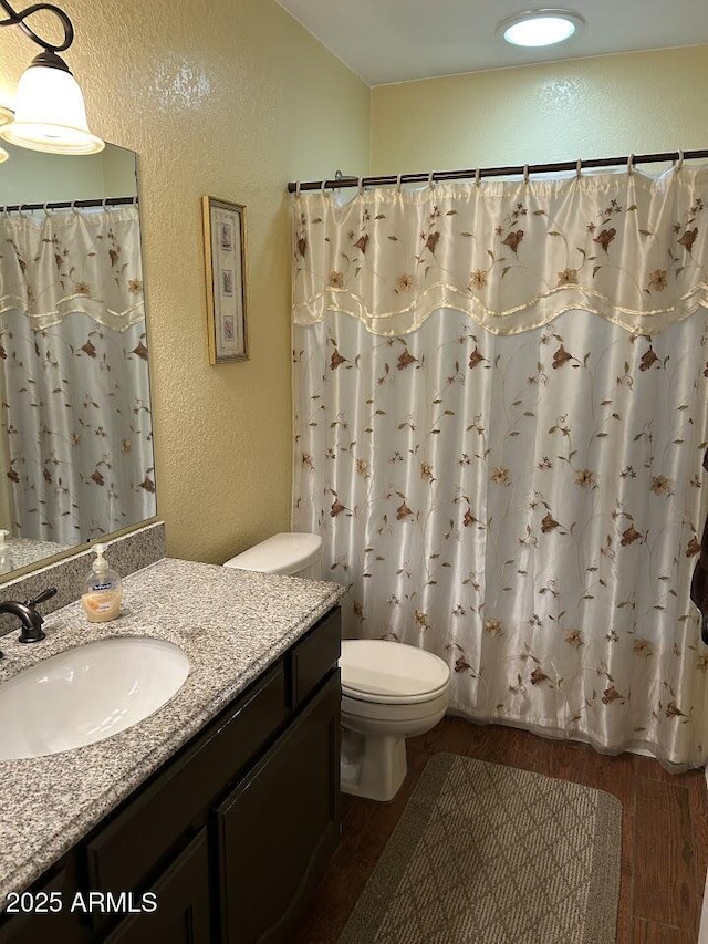 8981 W Tuckey Ln, Glendale, AZ 85305 - bathroom featuring a textured wall, wood finished floors, vanity, toilet, and curtained shower