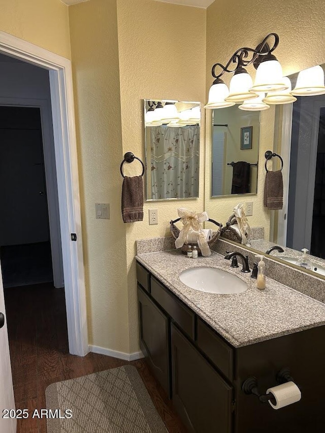 8981 W Tuckey Ln, Glendale, AZ 85305 - bathroom with a textured wall, wood finished floors, vanity, baseboards, and a chandelier