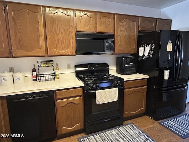 8981 W Tuckey Ln, Glendale, AZ 85305 - kitchen with black appliances, light wood-style flooring, and light countertops