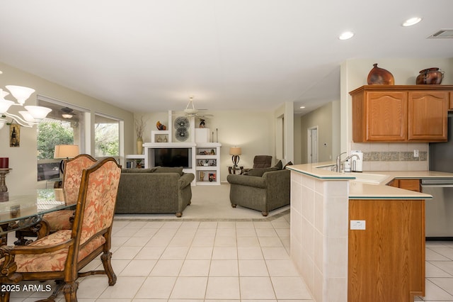 kitchen featuring visible vents, dishwasher, open floor plan, a peninsula, and light countertops