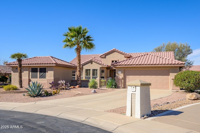 mediterranean / spanish-style home with a garage, driveway, a tiled roof, and stucco siding