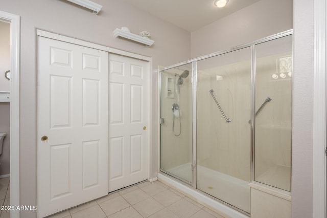 bathroom with tile patterned flooring and a shower stall