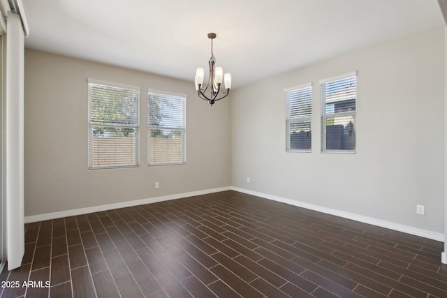 unfurnished room with an inviting chandelier