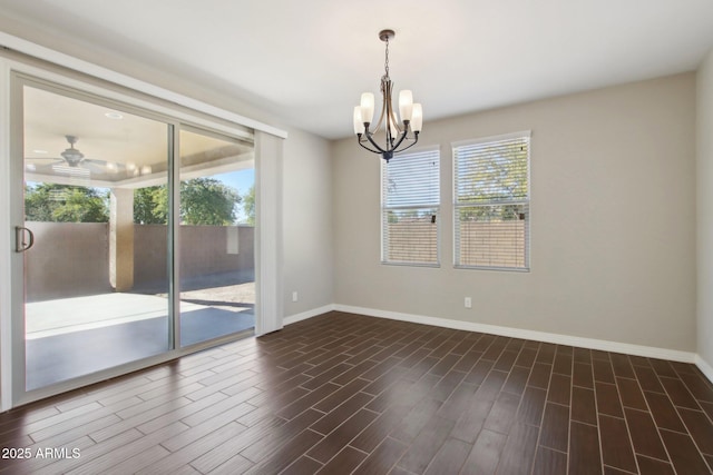 spare room featuring ceiling fan with notable chandelier