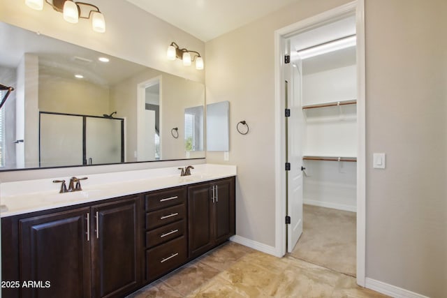 bathroom with a shower with shower door and vanity