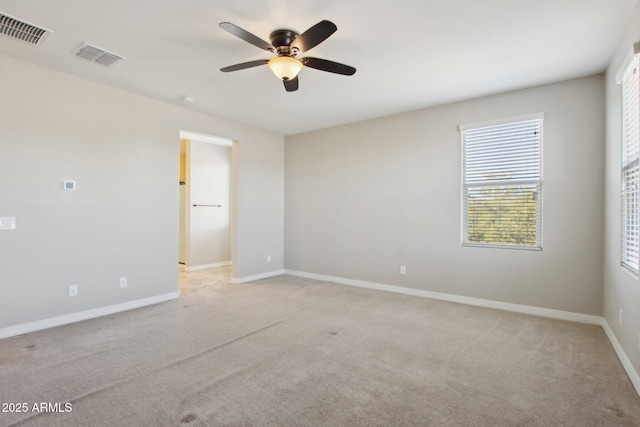 carpeted spare room featuring ceiling fan